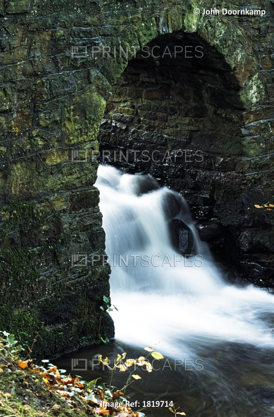 RUSHING WATER UNDER ARCHWAY, PENNINES, ENGLAND