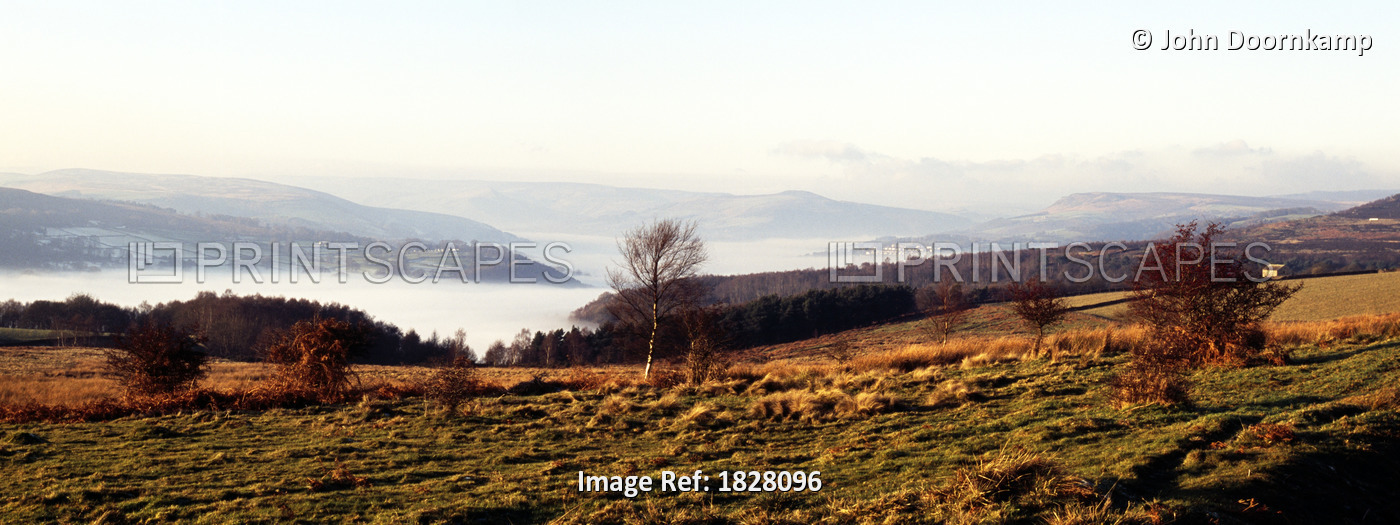 VIEW ACROSS FIELDS TO A MIST COVERED VALLEY DERBYSHIRE PEAK DISTRICT