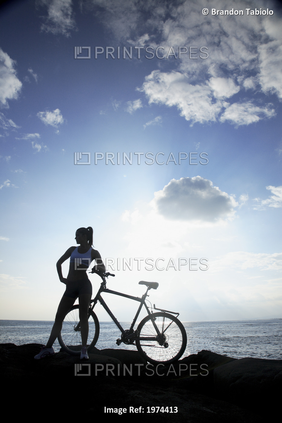 Hawaii, Oahu, Silhouette Of A Woman With A Bike On A Rocky Coastline.