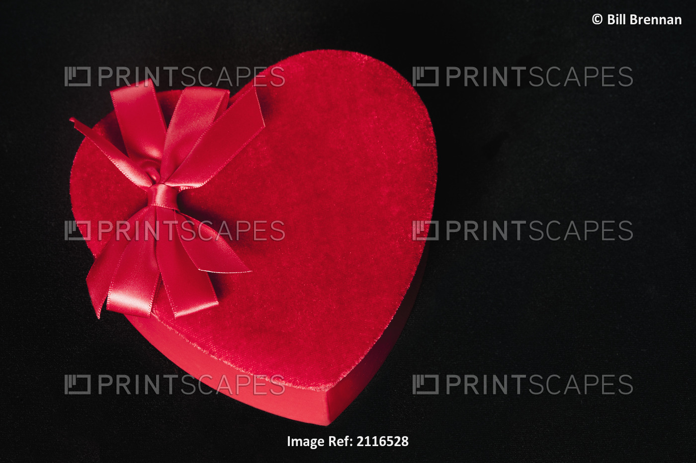 Valentines heart-shaped candy box against black background.