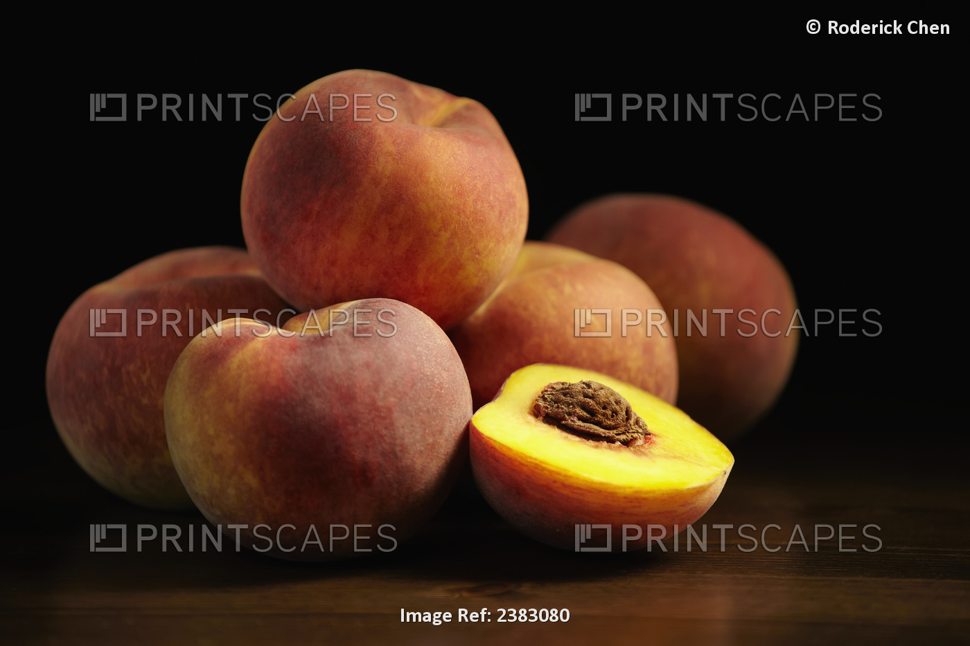 Peaches Sitting On A Wooden Table, One Cut In Half; Montreal, Quebec, Canada