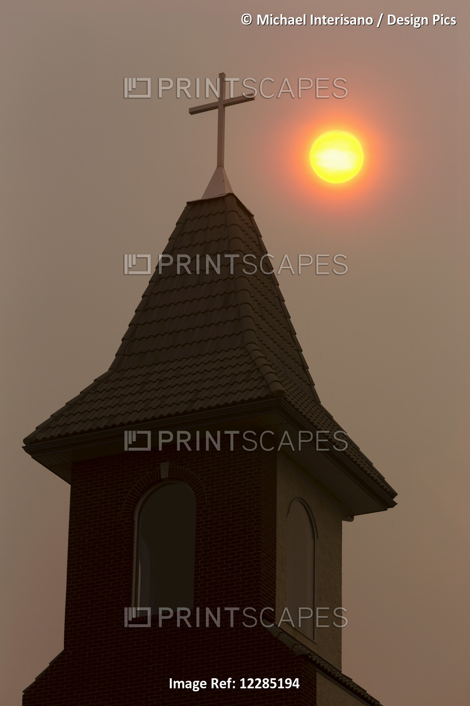 Silhouette Of Church Steeple With Orange Sun Ball In A Hazy Sky; Calgary, ...