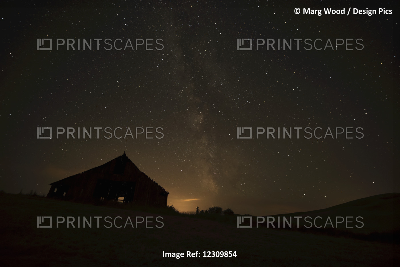 Night Sky Glowing Over Silhouette Of A Barn With A Peaked Roofline; Palouse, ...