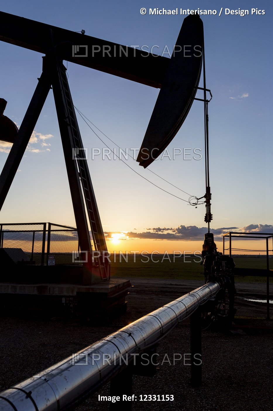 Silhouette Of A Pump Jack Head And Well Head With Pipes At Sunrise With A ...