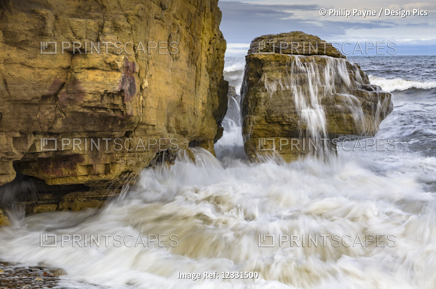 Incoming tide splashing on rock on Northeast England coast; Whitburn, Tyne and ...