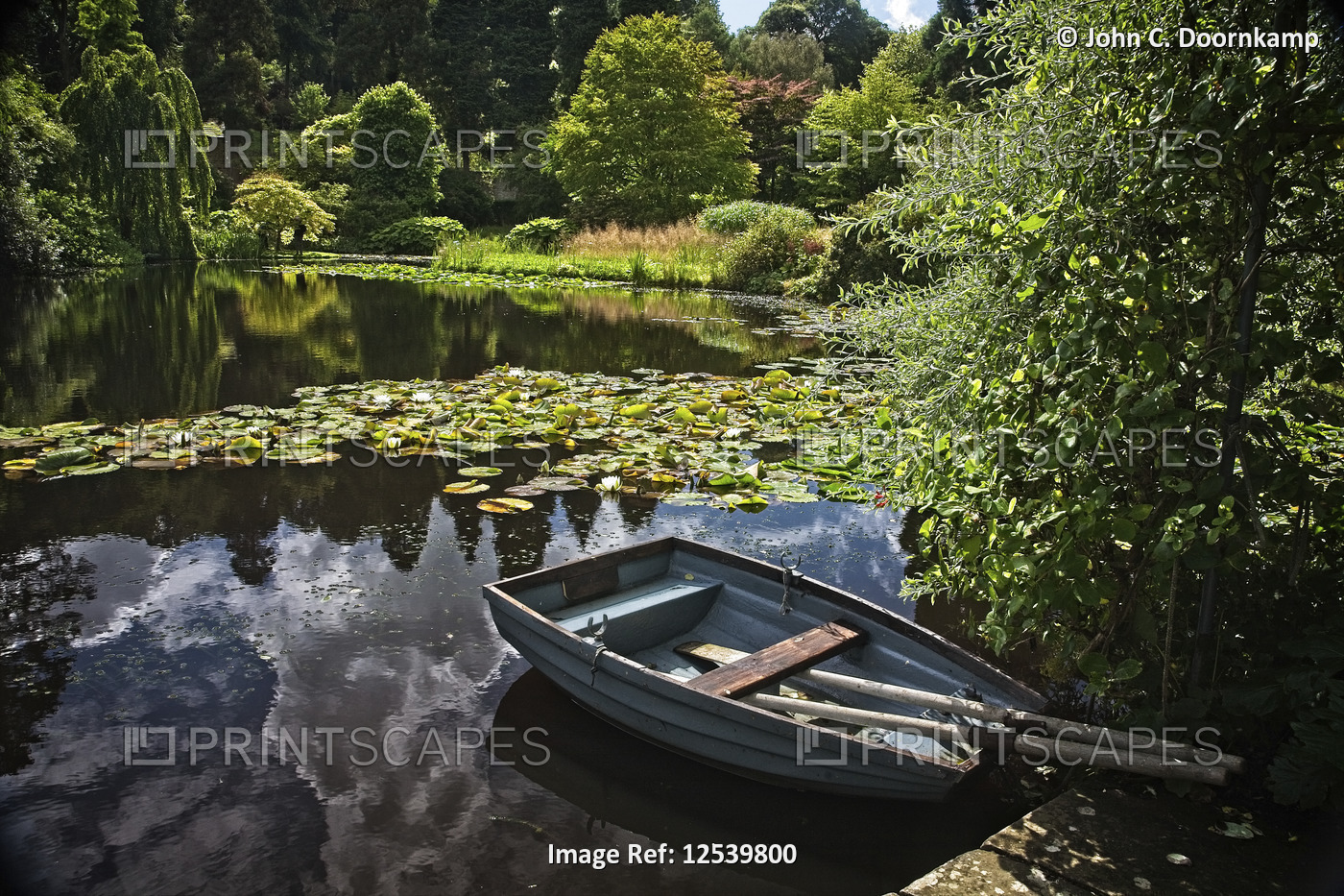 A MOORED BOAT ON A LARGE GARDEN POND IN ENGLAND