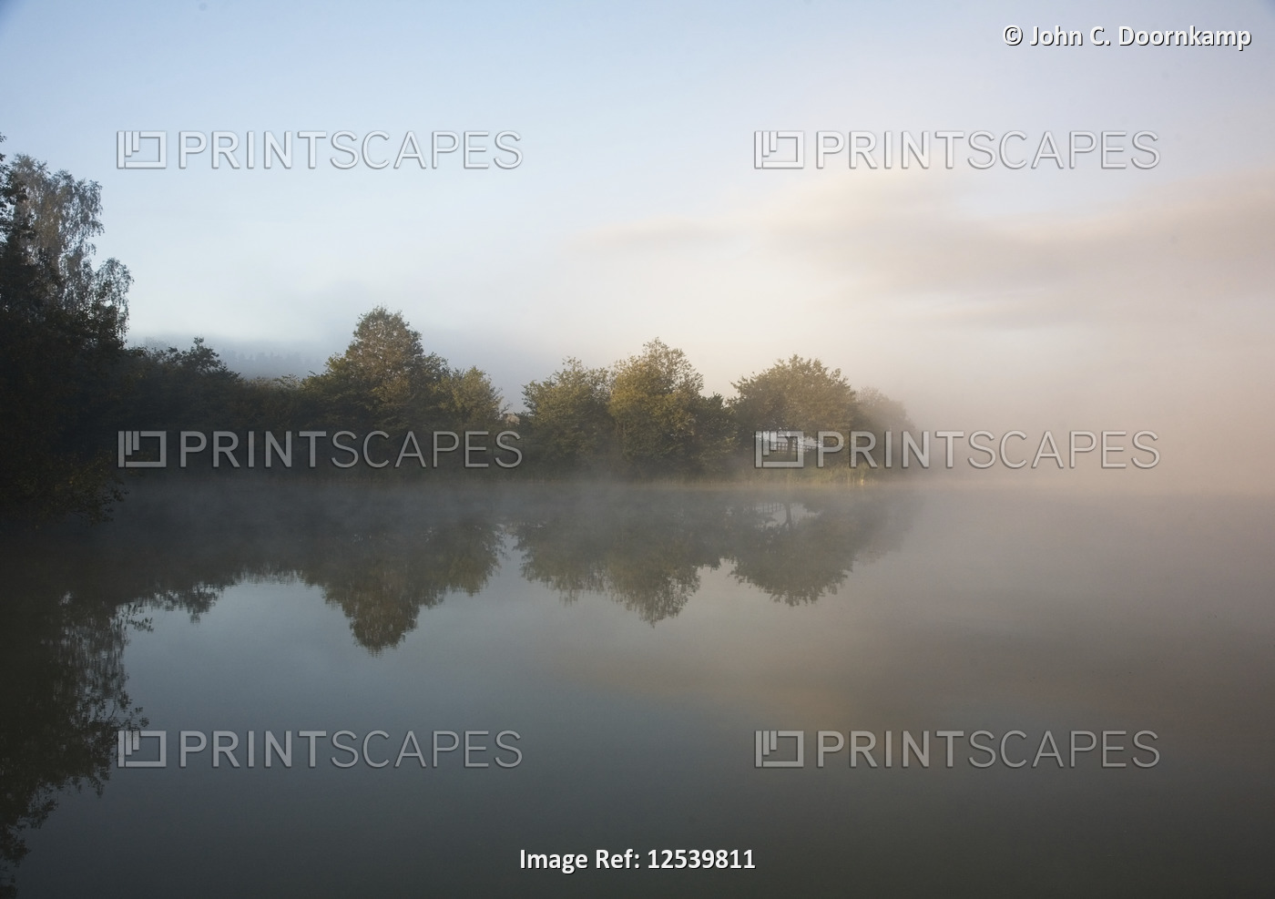 EARLY MORNING MIST OVER A LAKE IN THE ARDENNES, BELGIUM