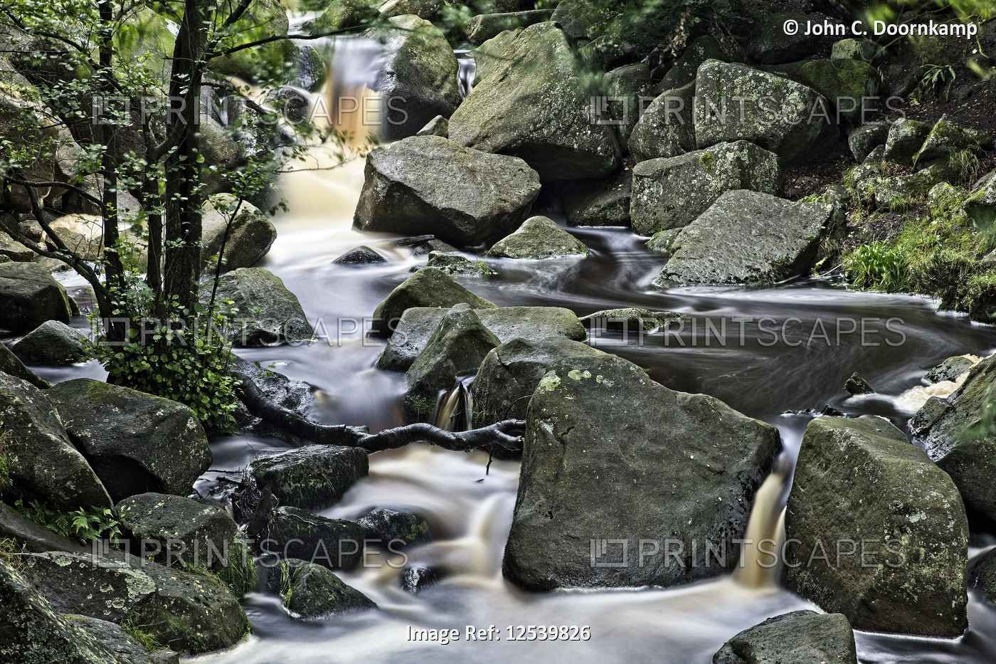 FAST FLOWING AND FALLING STREAM AMONGST BOULDERS