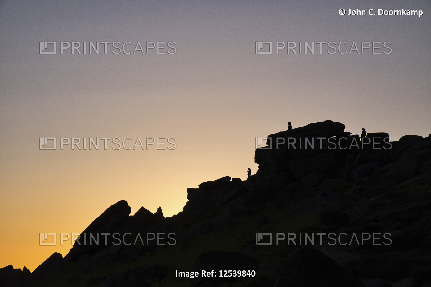 THE PROFILE OF A ROCKY OUTCROP AGAINST A SETTING SUN STANGE EDGE DERBYSHIRE ENGLAND