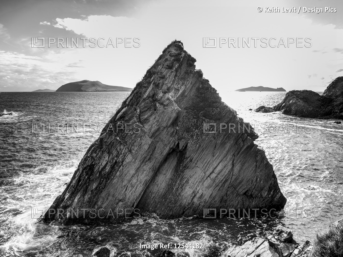 Rugged peak of a rock formation in the ocean along the coastline; ...