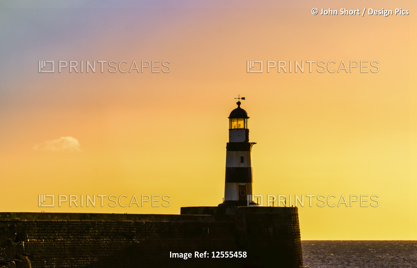 Lighthouse with golden sky at sunset; Seaham, Durham, England