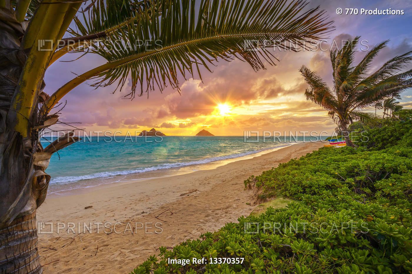 Lanakai Beach at sunrise, with the surf washing up on the golden sand and a ...