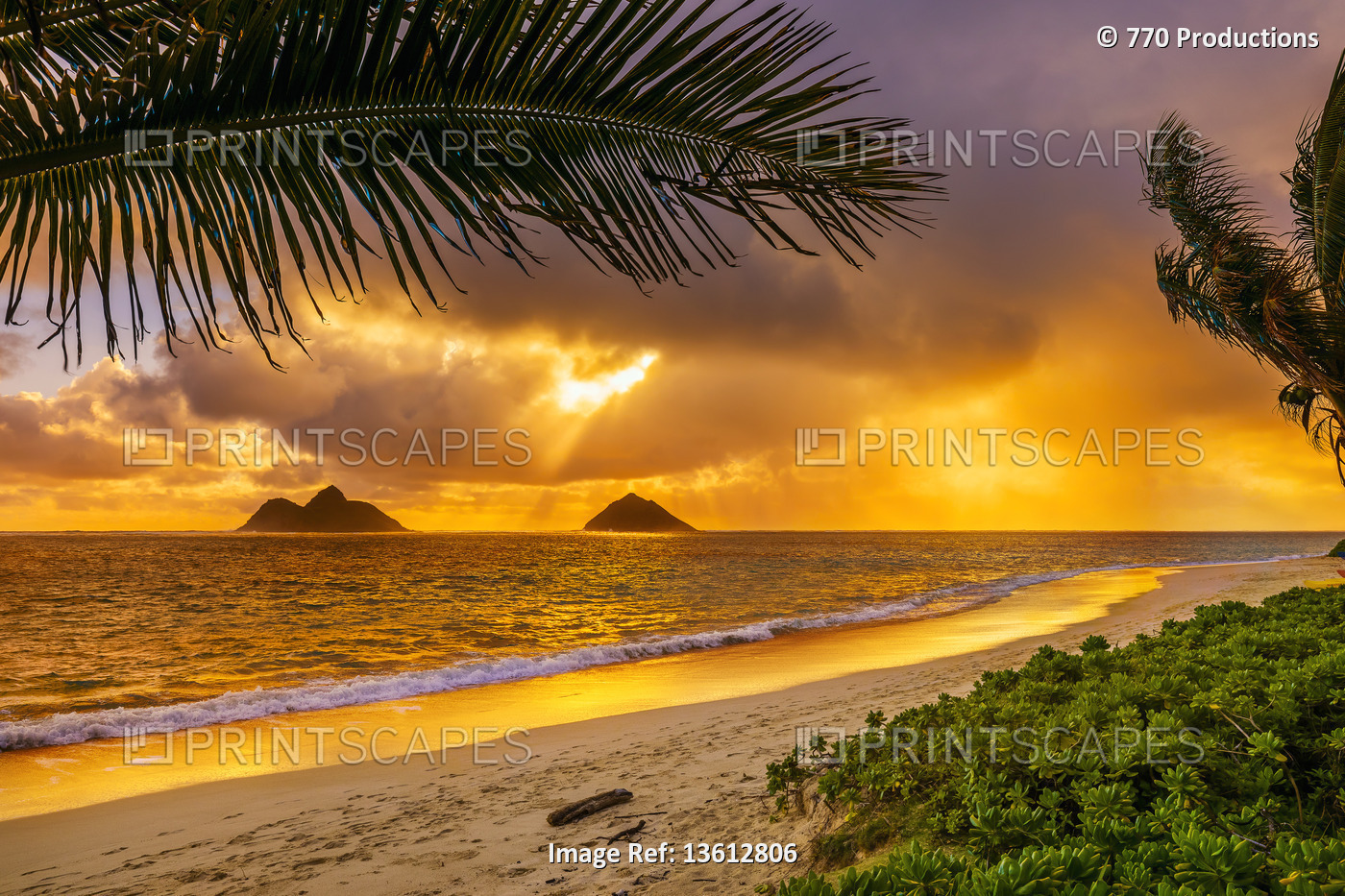 Sunrise viewed from Lanikai Beach with a view of the Mokulua Islands off the ...