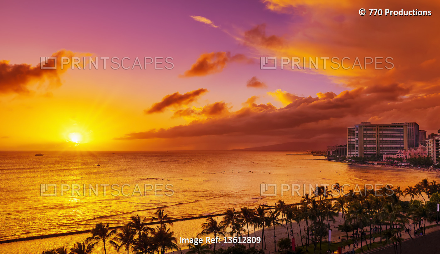 Condominiums and palm trees along the coastline of Waikiki at sunrise; ...
