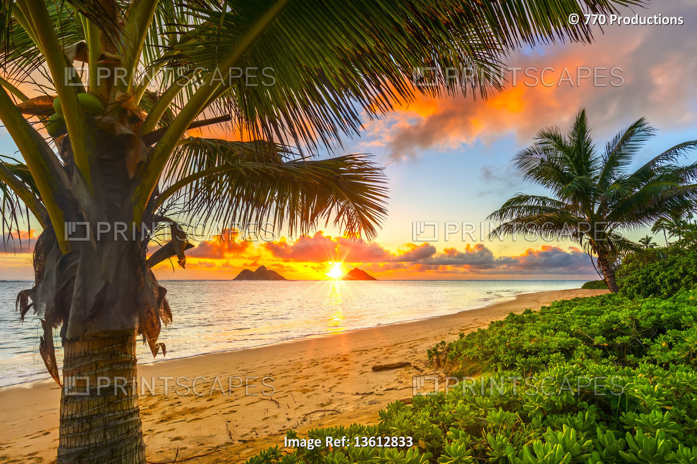 Bright sunrise over Mokulua Islands, viewed from Lanakai Beach on the coast of ...
