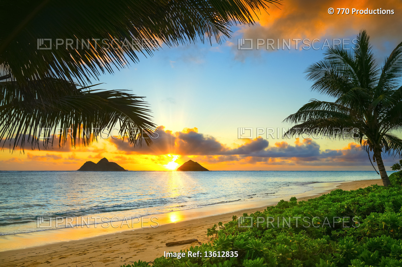 Bright sunrise over Mokulua Islands, viewed from Lanakai Beach on the coast of ...