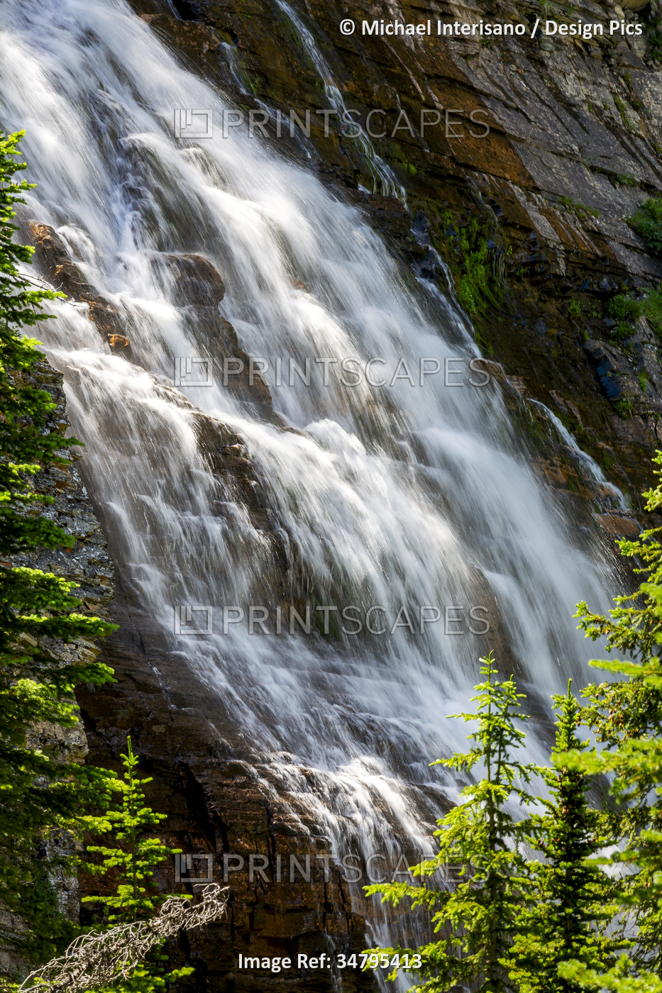 Cascading waterfalls against a rock cliff in Waterton Lakes National Park; ...